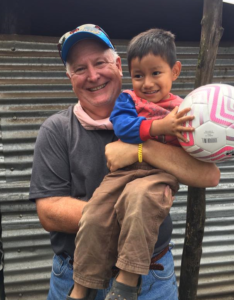 Lee Harlan with Guatemalan boy holding a soccer ball